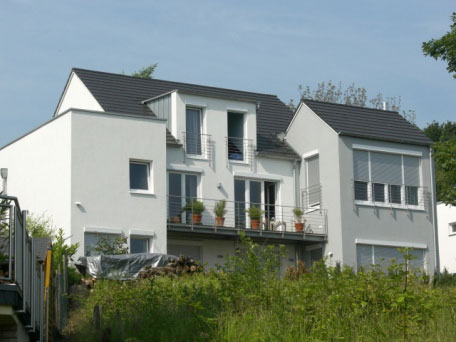 Weißes Doppelhaus mit Dachterrasse und Gauben