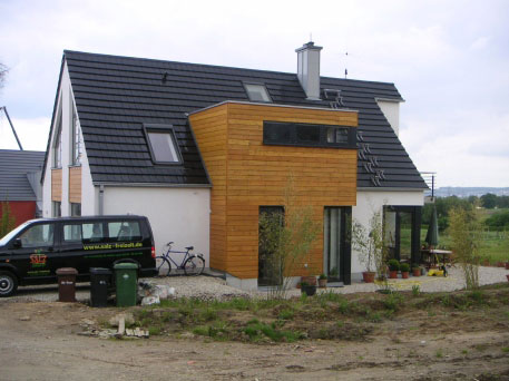 Weißes Einfamilienhaus mit Lärchenholz-Erker
